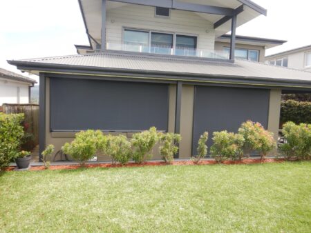 Front of home with Titan Grey Ziptrak blinds closed over a window and door.